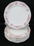 Seis (06) pratos rasos em porcelana branca, borda movimentada decorada com rosáceas. Med. 23 cm diâmetro.