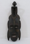 ARTE AFRICANA-Máscara ritualística esculpida em monobloco de madeira nobre  , representando " Rosto masculino" com figura repousada acima de sua cabeça, etnia Senufo,  // República da Costa do Marfim, séc. XX. Med. 56 cm alt.