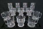Doze (12) peças em vidro prensado sendo: A) Quatro copos longos, base oitavada, bojo no formato dedão (14,5 x 8 cm),B) quatro copos, base redonda, bojo decorado com guirlandas (10,5 x 9,5 cm diâm),C) Quatro canecas em vidro italiano, fundo estrelado, marcada ( 11 alt x 8 cm diâm)