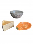 Três peças em cerâmica, sendo um bowl Luiz Salvador com relevo de ramagem, um formato de queijo e um no formato de mamão, apresenta lascado. Alt. 6 x 15, Diam. 11x 9 e  17 x 11 cm.