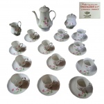 Guarnição café em porcelana francesa Limoges marcado na base decorada com flores e ramagens policromadas sobre fundo branco composto de:  12 xícaras com pires, 1 bule, 1 cremeira e 1 açucareiro, Alt. bule: 24, açucareiro, 25 e  cremeira 15 cm. Total: 15 peças.