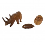 Três peças em madeira, 1 rinoceronte, 1 figura nativa e 1 flauta indígena,  16 x 6, Alt. 9 cm.