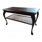 Mesa de centro em madeira nobre tampo recortado, pernas curvilíneas arrematas em prateleira com galeria em palhinha indiana, íntegras, tampo com leve mancha, 99 x 50, Alt. 56 cm.