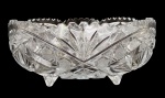 TCHECOSLOVAQUIA - Centro de mesa em denso cristal tcheco, formato circular apoiado sobre quatro pés, farta lapidação, borda entrecortada. Mede 24cm diâmetro.