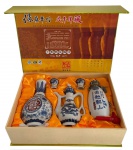 Caixa contendo dois vinhos de arroz origem chinesa, marca SHAOXINGG HUANGGJIU acondicionados em garrafas de porcelana oriental, um porta vinhos e dois cálices. Caixa original com proteção de seda dourada. Mede 27 x 38cm.