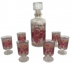 Conjunto francês composto por garrafa com tampa lapidada e 6 cálices em vidro transparente, decorados com estampa em vermelho e dourado com motivos de uvas e folhas. Marca em relevo FRANCE na base. Medida do maior 21cm.