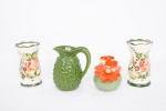 Lote constando de quatro peças decorativas diversas em cerâmicas vitrificadas e policromadas, sendo um vaso em cerâmica europeia no tom verde musgo com flor em alto relevo no tom coral e interior do vaso no mesmo tom, assinada na base - med. 14x6 cm de diâmetro na borda, jarra de água na forma de Abacaxi no tom verde degrade com relevos no bojo - med. 19x15x9 cm (com pequeno bicado na alça), e par de vasos em cerâmica vitrificada e policromada com decoração de flores, frutos e folhagens, borda e base ondulada - med. 19x11 cm de diâmetro na borda