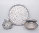 Lote constando de três peças Indianas em metal prateado, constando de uma grande bandeja redonda martelada, fundo decorado com cachos de uvas e folhas de parreira com flores e folhagens borda ondulada - med. 4x60 cm de diâmetro, vaso decorativo decorado com folhagens, parte central vazado - med. 22x15 cm de diâmetro na borda, e cachepot martelado - med. 20x28 cm de diâmetro na borda ( com desgastes causados por maresia)