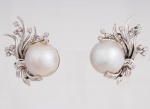 Elegante par de brincos de pressão da década de 50 em platina cinzelados na forma de laço, folhagens e flores cravejados com diamantes, com pérolas Mabe na parte central med. 3,2x2,5 cm, peso bruto aproximado 16,8 gr. Forma conjunto com o lote nº 224 - ESTE LOTE SOMENTE PODERÁ SER RETIRADO COM AGENDAMENTO PRÉVIO DE 48H DE ANTECEDÊNCIA, MEDIANTE CONFIRMAÇÃO DO PAGAMENTO, POIS NÃO ENCONTRAM-SE NO LOCAL DE REALIZAÇÃO DO LEILÃO
