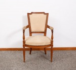 Cadeira estilo Luiz XVI em madeira no tom claro, encosto recortado, com braços curvos e pernas frisadas, encosto, almofadas nos braços e assento estofado em tecido no tom bege floral med. 93x56x54 cm (tecido com desgastes de uso, com pequena falha na madeira na parte superior direita e pequenos desgastes no verniz).