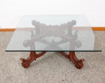 Mesa de centro da antiga loja Renascença. Tampo quadrado em cristal, base em cerejeira ricamente entelhada com volutas, pernas e pés curvos com amarração na base, acabamento na forma de pinha med. 43x110x110 cm (com pequeno trincado interno em uma lateral, um pequeno defeito na trave da amarração na base).