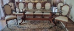 Conjunto de mesa de jantar e oito cadeiras em cerejeira, mesa com tampo retangular em cristal  apoiado sobre duas bases torneadas e entalhadas com seis pés curvos com uma trave central, acompanha oito cadeiras estilo Luiz XVI com encostos torneados e entalhados, colunas laterais frisadas encimadas por bilros e guarnições em metal cinzelados na forma de flores, pernas frisadas, encostos e assentos estofados em tecido no tom bege com decoração floral ( quatro cadeiras com pequenas falhas na madeira das pernas, uma delas com encosto bambo precisando de ajuste) - mesa - med. 77x220x105 cm - cadeiras  - med. 100x53x47 cm (algumas com desgastes no verniz, estofados com desgastes de uso) - esta peça está armazenada em um guarda móveis, precisando ser agendada com antecedência a retirada do mesmo