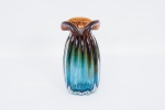 Vaso em vidro artístico de Murano, borda ondulada e bojo decorado com gomos em alto relevo, nos tons de âmbar e azul degradê med. 22x12 cm.