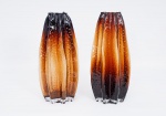 Par de vasos decorativos em vidro artístico no tom âmbar degradê, bordas onduladas e bojos com gomos e bolhas em alto relevo, med. 35x12 cm de diâmetro na base.