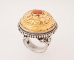 Imponente anel Indiano em prata de lei cinzelado com flores e arabescos, parte superior com banho de ouro, parte central com placa em coral, med. 3,2 cm de diâmetro - aro 22, peso bruto aproximado 34.4 gr.