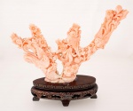 Belíssima e antiga escultura Chinesa em coral peau D'ange, ricamente esculpida representando tronco com pássaros, flores e folhagens, base em madeira exótica entalhada com aplicação de fios possivelmente de prata apoiada sobre quatro pés med. 15x10x4 cm (base com três colados).