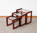 Mesa auxiliar dita "três Marias" da década de 80 em madeira envernizada, tampos retangulares em vidro fumê, pernas retas com traves nas laterais das bases med. 50x58x35 cm (a maior), 43x47x34 cm e 36x37x32 cm (a menor) com pequenos desgastes no verniz).