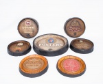 Lote constando de sete placas redondas de parede decorativas, sendo cinco em ficha de vidro e duas em papel marchê policromadas, decoradas com marcas de Whisky e de cervejas policromadas med. 4x26 cm (a menor) e 6x38 cm de diâmetro (a maior). Uma placa com pequeno defeito na borda).