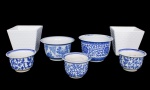Lote constando de sete cachepots em cerâmica sendo cinco nas cores azul e branco com decoração floral - três - med. 9x14 cm de diâmetro ( com manchas de uso e bicados na base), dois cachepots - med. 12x18 cm e 13x19 cm e dois cachepots brancos decorados com esferas ( um com fio de cabelo) - med. 17x19 cm