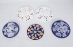 Lote constando de cinco descansos para travessas em cerâmica vitrificada sendo duas na cor branco decoradas com flores e folhagens vazadas - med. 26 cm de diâmetro, e três policromadas duas decoradas com flores e folhagens vazadas - med. 20 cm de diâmetro e 26 cm de diâmetro e uma decorada com peixes e mariscos - med. 22 cm de diâmetro, quatro da manufatura Luiz Salvador