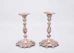 Antigo par de castiçais europeus cerca de 1900 em metal espessurado a prata, ricamente cinzelados com folhagens e volutas, com bobeches podendo ser retiradas, base recortada - med. 12x24 cm na base (com pequenos desgastes do tempo)