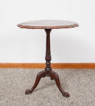 Antiga mesa auxiliar  - gueridon - em madeira nobre, tampo redondo recortado, coluna central torneada e entalhada apoiada sobre três pernas curvas com pés de garras - med. 62x54 cm de diâmetro, tampo feito em duas partes (tampo com manchas e desgastes no verniz)