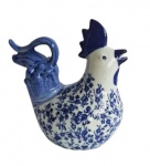 Delicada galinha em porcelana, ricamente policromada em tons branco e azul. Medidas 18x19x11cm.