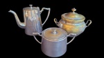 Lote contendo 2  açucareiros e 1 bule em metal prateado. Medidas Bule 14 cm, açucareiros 14cm e 9 cm. A presentam desgastes.