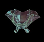 Pequena fruteira em cristal translúcido, com 4 pés e borda onduladas remetendo a movimento. Medidas 15x15x10cm.