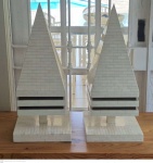Par de grandes esculturas de madeira em forma de Prisma revestidas em plaqueado de material ósseo em bom estado de conservação medindo 70 cm de altura por 30 cm por 30 cm, retirada em local térreo em condominio na Av das Américas altura do Riviera del Fiori.