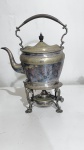Samovar em metal espessurado a prata, base suspensas hastes recurvas, pequenos desgastes no banho de prata. Conjunto necessitando de polimento, altura total de 30 cm.