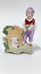 Escultura de porcelana alemã policromada representando figura masculina  com cachorro