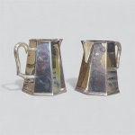 Par de Elegante jarras  em metal com banho de prata, corpo facetado. Medidas: 17,5 X 10 cm.