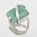 Anel prateado com elaborada base de pedra sintética verde. Aro 20. Base 4x3 cm