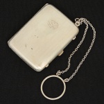 PRATA, uma (1) antiga trousse, ornada com frisos, traz marca possessória monogramada, além de datação 14-9-48,medindo 6 x 4,5 cm mais châtelaine, peso aproximado 56,9 gr., sinais de uso, vide foto.