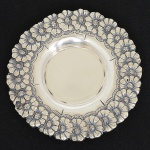 PRATA PORTUGUESA, um (1) porta aliança, borda com ornamentação relevada em flores, punções Águia(contrastaria da cidade do Porto), além de marca de ourives, medindo 9 cm diâmetro, peso aproximado 18,9 gr., sinaisde uso, vide foto.