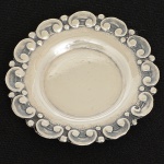 PRATA PORTUGUESA, um (1) porta aliança, borda com ornamentação relevada em perolados e volutas, punções:Águia 925 e marca de ourives, medindo 5 cm diâmetro, peso aproximado 4,8 gr., sinais de uso, vide foto.