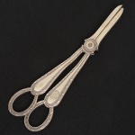 METAL PRATEADO, uma (1) tesoura de mourão, ornamentação relevada em frisos e perolados, marca possessóriamonogramada, pertenceu ao GRAND HOTEL GUARUJA, manufatura MAPPIN & WEBB, medindo 18,5 cmcomprimento, sinais de uso, vide foto.