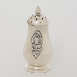 PRATA, um (1) polvilhador com ornamentação figurativa relevada representando BUDDHA (popularmenteconhecido como SIDDHARTHA GAUTAMA, foi um príncipe de uma região no sul do atual Nepal que, tendorenunciado ao trono, se dedicou à busca da erradicação das causas do sofrimento humano e de todos os seres, e destaforma encontrou um caminho até ao despertar ou iluminação), encimado por cone, pé baixo, tampa rosqueável, mossasna base, puncionado MADE N SIAM STERLING, medindo 6 cm altura, peso aproximado 21 gr., sinais de uso, videfoto.