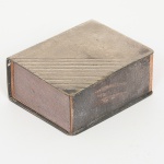 METAL PRATEADO, uma (1) antiga fosforeira, sem marca de manufatura aparente, detalhes em frisos, medindo 6x 5 x 2,5 cm, acompanha antiga caixa de fósforo vazia da marca CLUBE (origem Portugal), sinais de uso, vide foto.