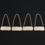 METAL PRATEADO, quatro (4) identificadores para garrafa de bebida, com as legendas: JEREZ; COGNAC; OPORTO; WHISKY, retangulares com quinas chanfradas, levemente curvos, medindo 6 x 2 cm mais a corrente, todoscom sinais de uso, vide foto.