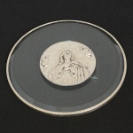 JOIA SACRA PORTUGUESA, uma (1) antiga medalha com busto do Sagrado Coração de Jesus, halo estrelado,anjos em torno, assinado T. TUNA, fixado em cristal bisotado, incolor e translúcido, punções portugueses Águia dacontrastaria do Porto e marca de ourives, medindo 11 cm diâmetro, vide foto.