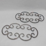 Dois suportes para pratos quentes em metal prateado. Comp. 35 cm.