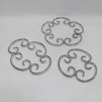 Três descansos para pratos quentes em metal prateado. Diam. 16 a 2 cm.