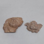 Duas esculturas de anjos querubins em pedra sabão. Um Delas colada.  Med. 6,5 e 10 cm.