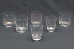 Seis copos em vidro translúcido: quatro p/ uísque lapidados com círculos e dois para aperitivos lapidados com folhagens (bicado e rachado na borda). Alt. 8 cm.
