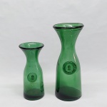 Duas jarras de vidro verde para decantação de vinho, no bojo as inscrições "ROMA - 1/2 LITRO" e "ROMA 1 LITRO". Alt. 19 e 25 cm.