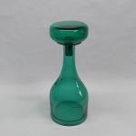 Garrafa bojuda em vidro verde com tampa. Rachadura no bojo. Alt. 29 cm.