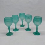 Cinco taças para vinho em vidro verde satinê, base redonda, haste e bojo lisos. Alt. 17 cm.