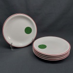 Cinco pratos para sobremesa em porcelana branca, borda decorada com linha vermelha, círculo verde. Marcados SCHMIDT - MESBLA. Diam. 19 cm.
